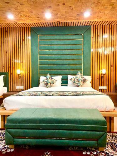 a bedroom with a large bed with a green headboard at Hotel Woodville Inn - Hotel in Mcleodganj in McLeod Ganj