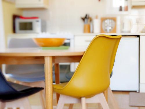 a yellow chair sitting at a table in a kitchen at 6 Avocet Quay, Emsworth in Emsworth
