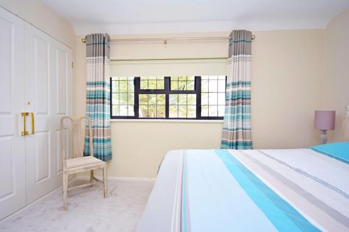 een slaapkamer met een bed, een stoel en een raam bij Bankside, Middleton in Middleton-on-Sea