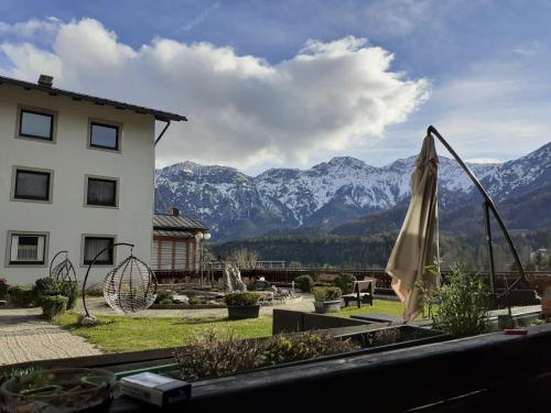 a patio with a umbrella and mountains in the background at Hotel Lindwurm in Bad Goisern