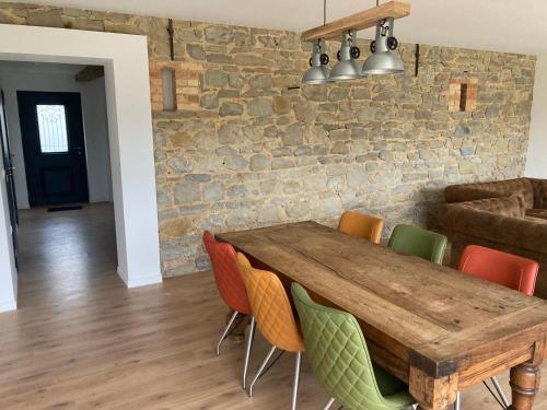 une salle à manger avec une table et des chaises en bois dans l'établissement Songes en Côte d Opale, à Conteville-lès-Boulogne