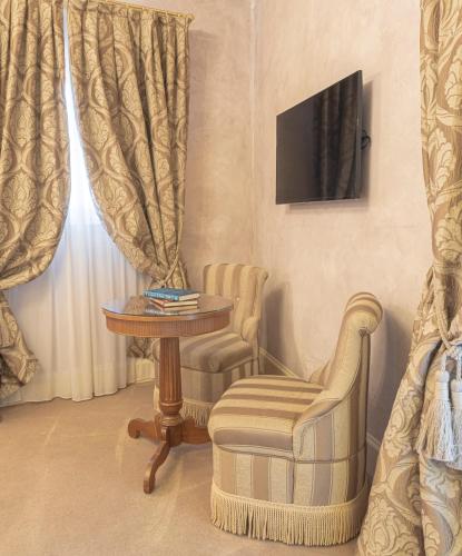 a living room with a chair and a table and a television at Hotel Villa Barbarich Venice Mestre in Mestre
