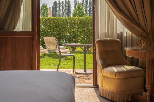 a bedroom with a door open to a patio with a table and chairs at Hotel Villa Barbarich Venice Mestre in Mestre