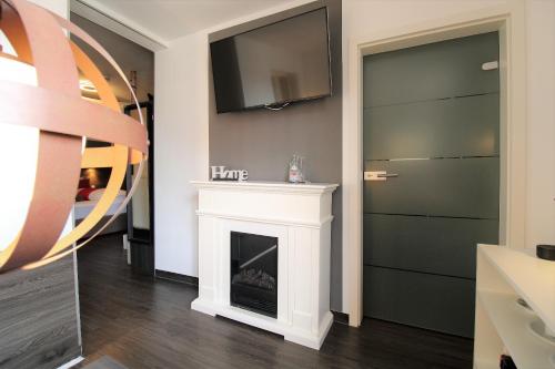 a living room with a fireplace and a flat screen tv at MY HOME Hotel Lamm Rottweil "Smart Home" in Rottweil