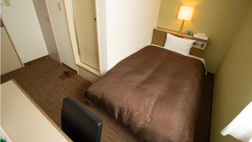 a small room with a bed in a hotel room at Hotel Yassa in Mihara