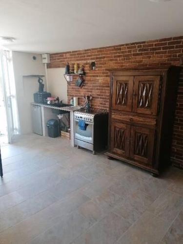 - une cuisine avec un mur en briques et une cuisinière dans l'établissement Les Sentiers Drômois, à Saint-Bonnet-de-Valclérieux