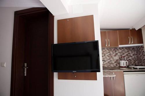 a flat screen tv on a wall in a kitchen at Can Apartments in Turunç