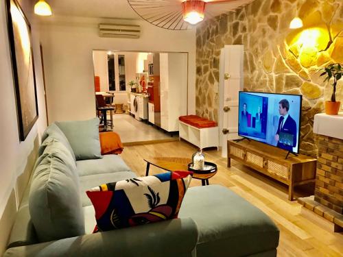 sala de estar con sofá y TV en Luxe calme et volupté avec vue panoramique sur le vieux port, en Marsella