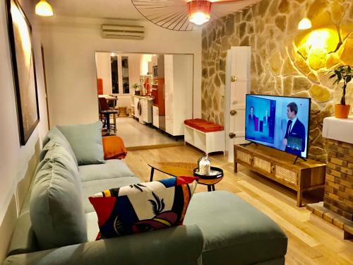 a living room with a couch and a tv at Luxe calme et volupté avec vue panoramique sur le vieux port in Marseille