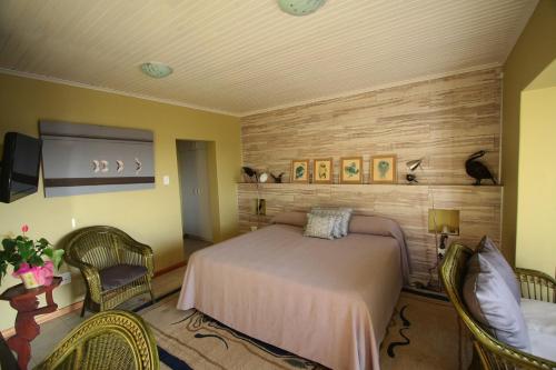a bedroom with a bed and chairs in a room at Lagoon Lodge in Walvis Bay