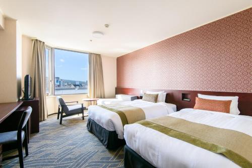 a hotel room with two beds and a window at Kanazawa Tokyu Hotel in Kanazawa