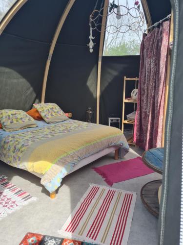 La CoudreにあるLa Tente Hippie Chicのテント内のベッド1台が備わるベッドルーム1室