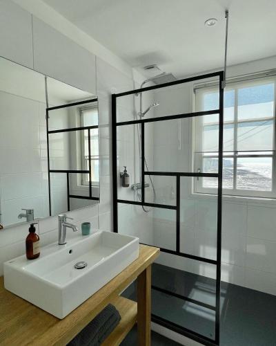a bathroom with a sink and a glass shower at Brise du Large - Maison d'Ault in Ault