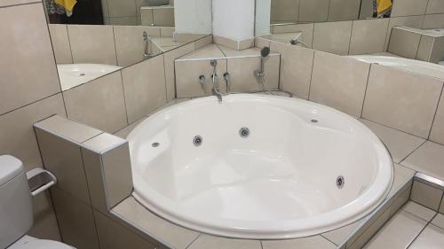 y baño con aseo y bañera blanca grande. en Hostal Tambo Alto, en Churín