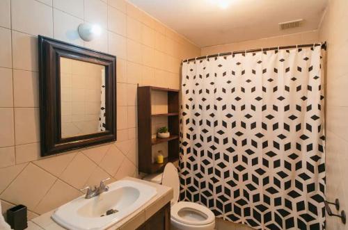 a bathroom with a shower curtain and a sink at Villa Detalles in Antigua Guatemala