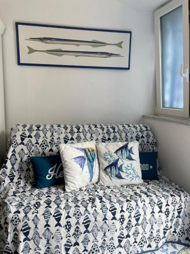 a couch with blue and white pillows in a room at Petit Maison Jeranto in Nerano