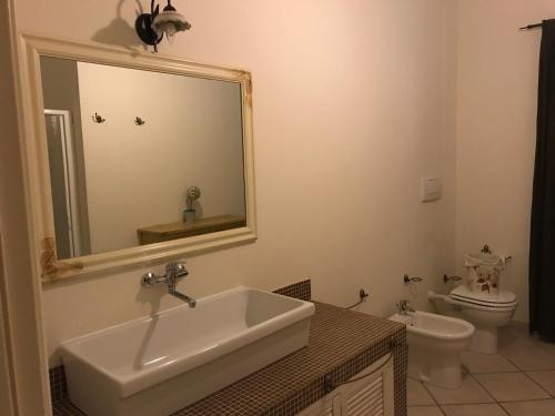 a bathroom with a sink and a toilet and a mirror at B&B VENTO DELL'EST in Potenza Picena