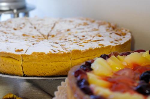 a cake sitting on top of a table next to a fruitcake at Villa Camporosso in Colà di Lazise