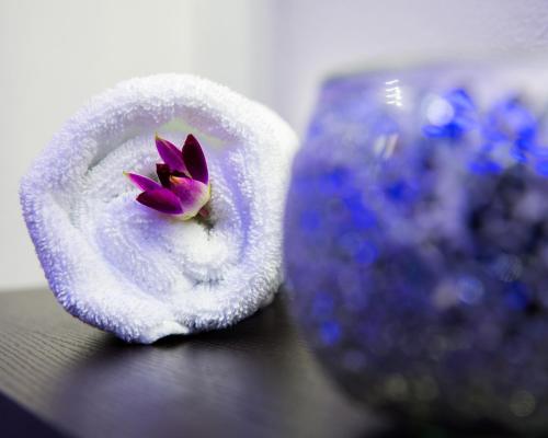 a purple flower in a towel next to a vase at Sealine Beach, a Murwab Resort in Mesaieed