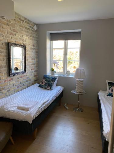 a bedroom with a bed and a brick wall at Brohuspark in Lomma