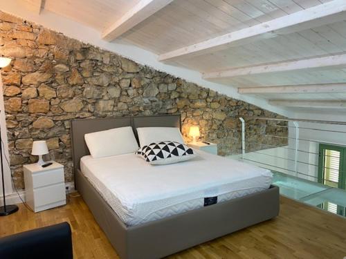une chambre avec un lit et un mur en pierre dans l'établissement Sunflower apartments, à Cannes