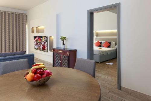 a room with a table with a bowl of fruit on it at Sealine Beach, a Murwab Resort in Mesaieed