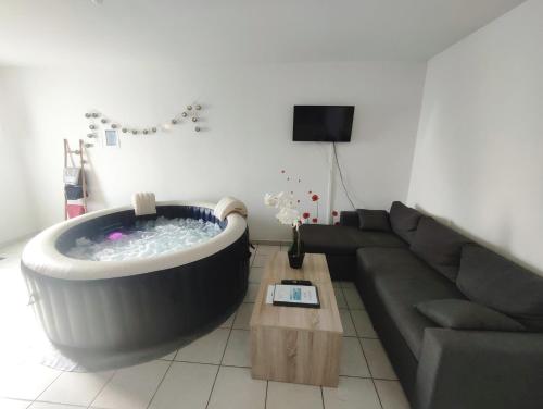una sala de estar con una gran bañera en medio de un sofá en Le Tribord T3 étoilé avec jacuzzi, en Saint-Méloir-des-Ondes