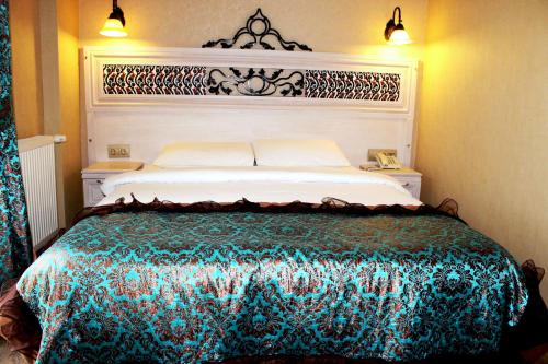 
a white bed with a blue comforter and pillows at Hotel Novano in Istanbul
