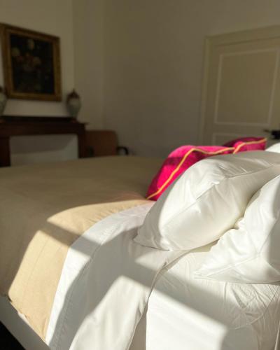 a white bed with white sheets and pillows at NOUBAR in Cénevières