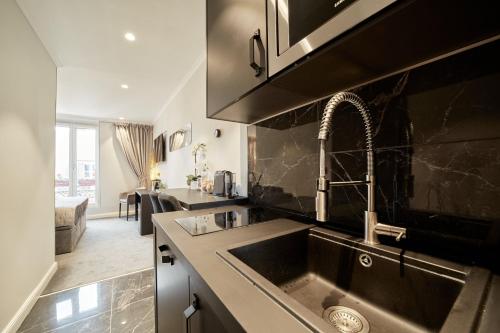 a kitchen with a sink and a counter top at Black Pearl Suite Luxe Centre-Ville Amiens à 200m de la Cathédrale in Amiens