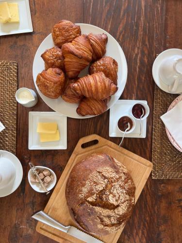 a table with a plate of pastries and a plate of bread at NOUBAR in Cénevières