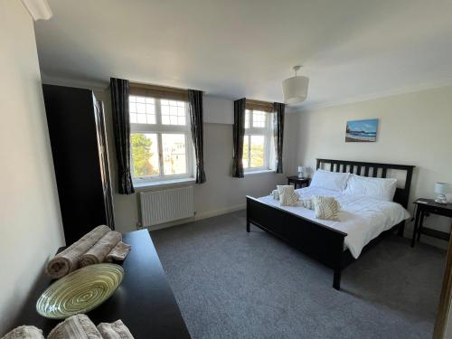 a bedroom with a bed and a couch and windows at Burlington Mansions in Bournemouth