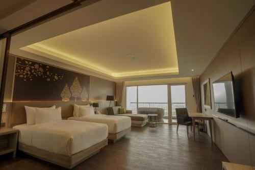 ein Hotelzimmer mit 2 Betten und einem TV in der Unterkunft Amaranta Prambanan Yogyakarta in Yogyakarta