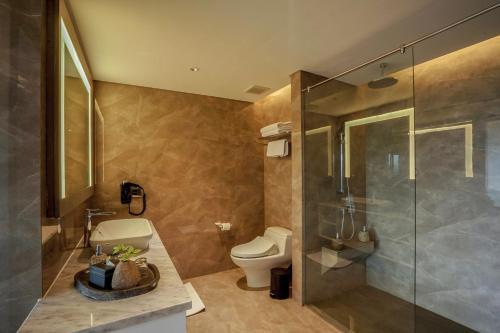 a bathroom with a toilet and a glass shower at Amaranta Prambanan Yogyakarta in Yogyakarta