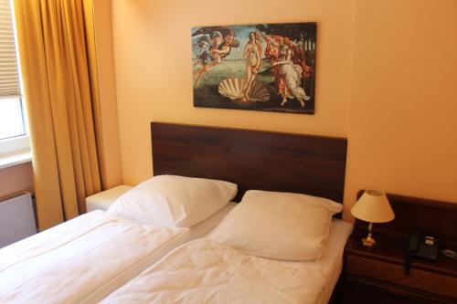 a bedroom with a bed and a painting on the wall at Wiking Hotel in Henstedt-Ulzburg