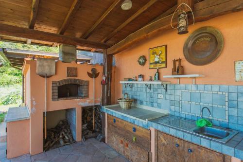 a kitchen with a sink and a fireplace at Fortino's Hause in Porto Santo Stefano