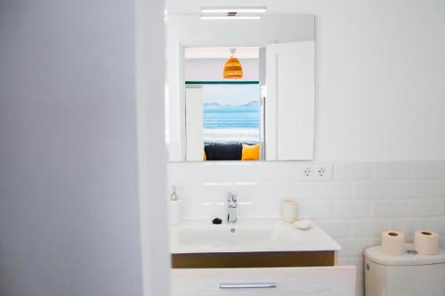 une salle de bain avec un lavabo et un miroir dans l'établissement Arena y el Mar, à Famara