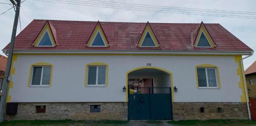 ein weißes Haus mit rotem Dach und grüner Tür in der Unterkunft Agro privat in Hrabušice
