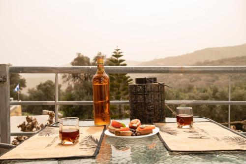 une bouteille d'alcool et une assiette de nourriture sur une table dans l'établissement Square Apartment, à Kambanós