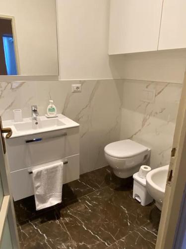 a white bathroom with a toilet and a sink at JUST LAKE in Bellagio
