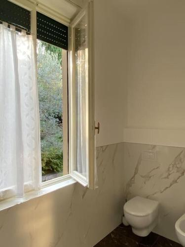 a bathroom with a toilet and a window at JUST LAKE in Bellagio