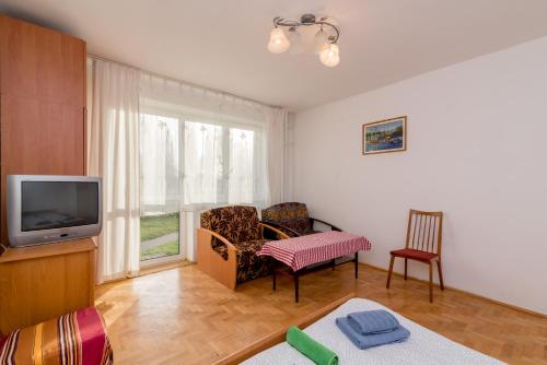 a living room with a tv and a couch and a chair at Rooms in the center in Gdańsk