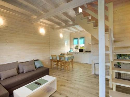 a living room with a couch and a table at Domki Turkusowe Zacisze in Sarbinowo