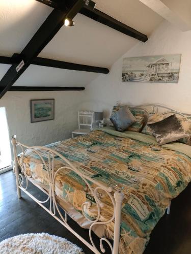 a bedroom with a large bed in a room at Fishermen's cottage with log burner, 2 bathrooms & sea views from garden terraces in The Mumbles