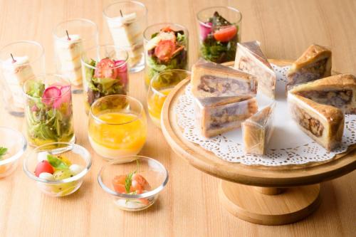 a table with a plate of sandwiches and glasses of wine at Kanazawa Tokyu Hotel in Kanazawa