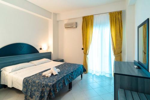 เตียงในห้องที่ Apulia Hotel Forte Club Scalea