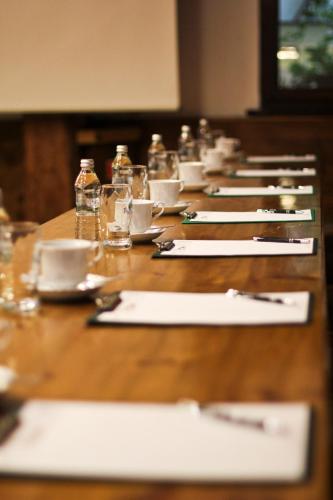a long wooden table with plates and napkins on it at Hotel Spichrz in Toruń