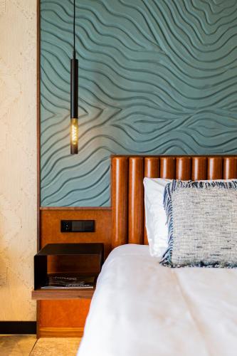 a bedroom with a bed with a wooden head board at Alexander Hotel in Noordwijk aan Zee