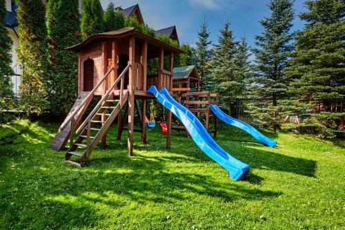 un parque infantil con toboganes y una casa de juegos en Hotel Skalny, en Zakopane