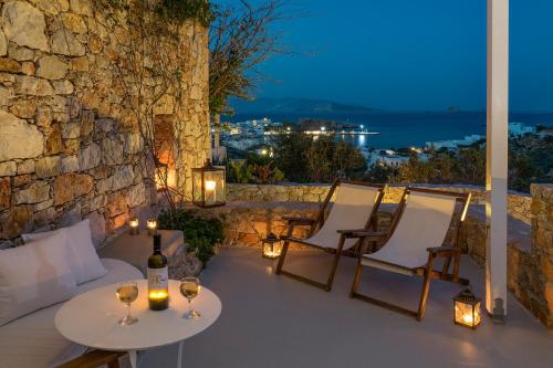 d'une terrasse avec 2 tables, des chaises et des lumières. dans l'établissement Zefiros, à Karavostasi